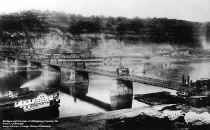 This photo, taken approximately 1880, shows the work in progress of replacing the old suspension bridge with the current Smithfield St. Bridge. The current bridge was built above and around the old bridge. The photo also shows the Packet Geneva in the foreground.